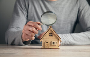 concept-real-estate-hand-businessman-hold-magnifying-glass-looking-house